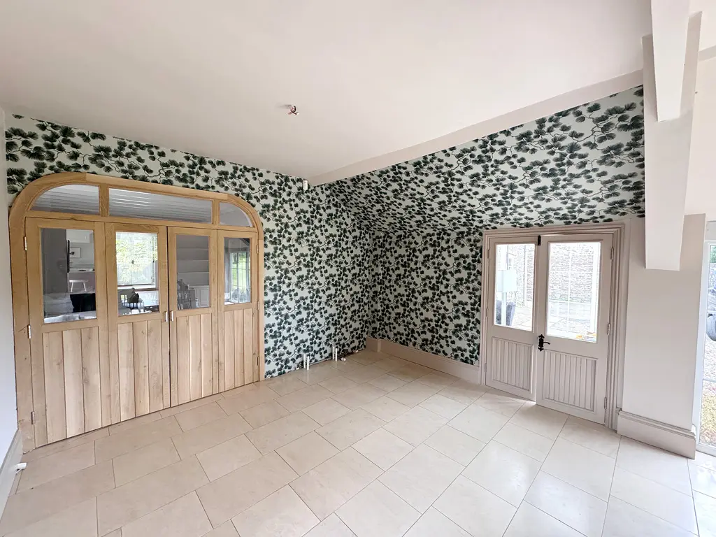 A newly decorated space with patterned wallpaper on the walls